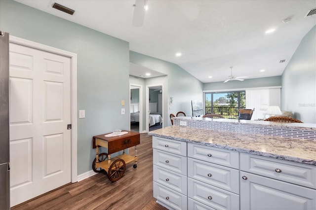 kitchen featuring light stone countertops, a ceiling fan, visible vents, dark wood-style flooring, and white cabinets