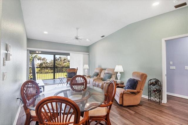 dining room with a ceiling fan, visible vents, wood finished floors, baseboards, and lofted ceiling