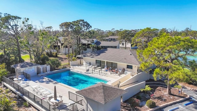 community pool with a patio and a fenced backyard