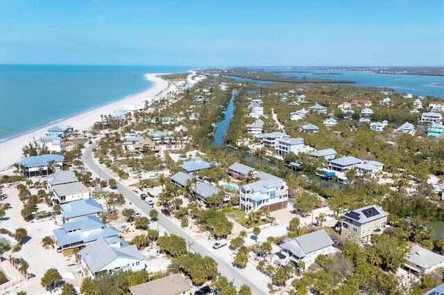 drone / aerial view featuring a water view, a residential view, and a view of the beach