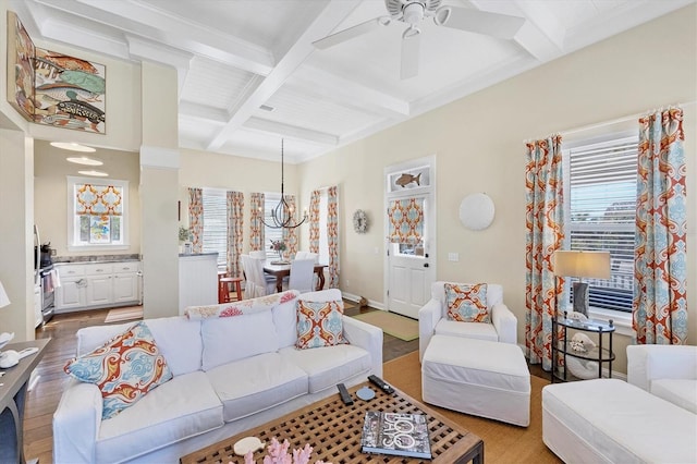 living room featuring baseboards, coffered ceiling, wood finished floors, beam ceiling, and ceiling fan with notable chandelier