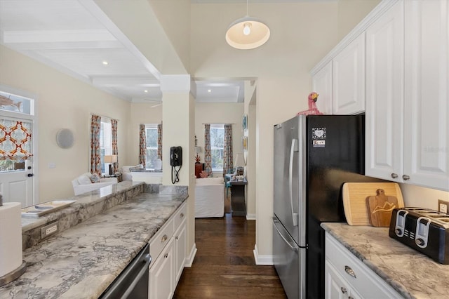 kitchen featuring light stone counters, white cabinets, appliances with stainless steel finishes, beam ceiling, and dark wood finished floors