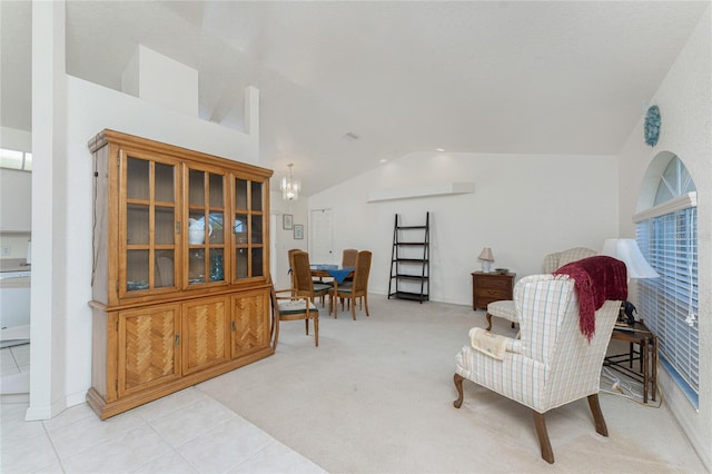 living area featuring light carpet, a chandelier, light tile patterned flooring, and vaulted ceiling