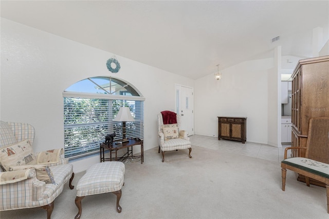 living area featuring visible vents, carpet, and vaulted ceiling