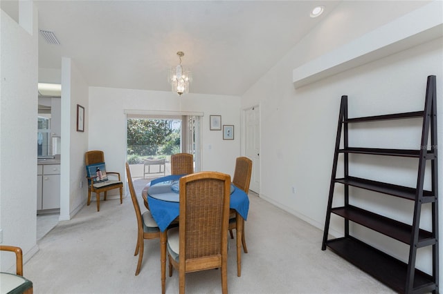 dining space featuring an inviting chandelier, light colored carpet, visible vents, and baseboards