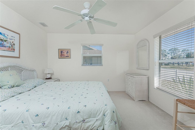 bedroom featuring visible vents, light colored carpet, and ceiling fan