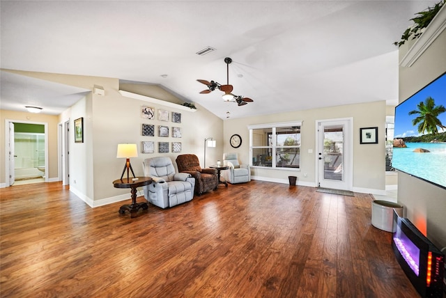 living area with visible vents, baseboards, lofted ceiling, wood finished floors, and a ceiling fan