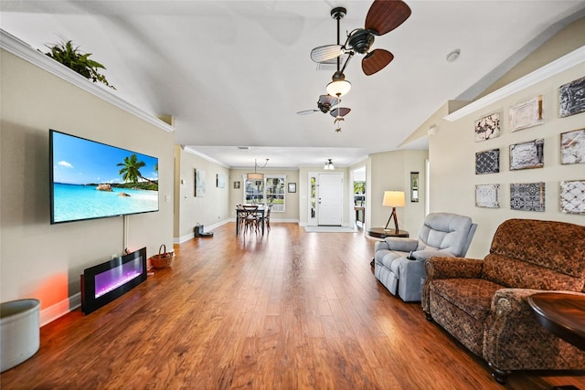 living area featuring baseboards, ornamental molding, a ceiling fan, and hardwood / wood-style flooring