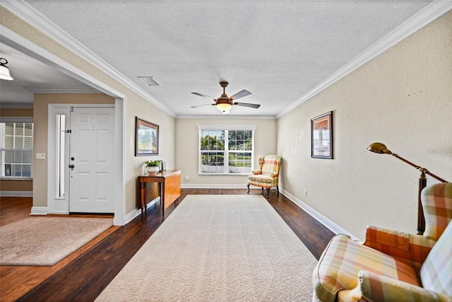 sitting room featuring visible vents, a textured ceiling, ornamental molding, and dark wood-style flooring