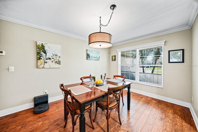 dining room with baseboards, ornamental molding, and hardwood / wood-style flooring