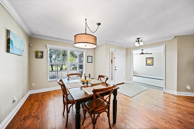 dining area featuring ornamental molding, ceiling fan, baseboards, and hardwood / wood-style flooring