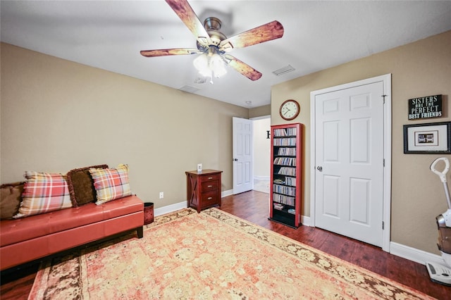 sitting room with visible vents, wood finished floors, baseboards, and ceiling fan