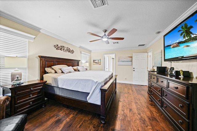 bedroom with dark wood-style floors, visible vents, and ornamental molding