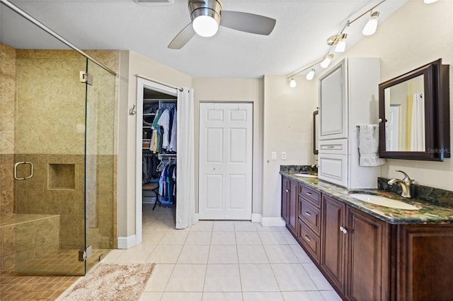 full bathroom with tile patterned flooring, a shower stall, double vanity, and a sink