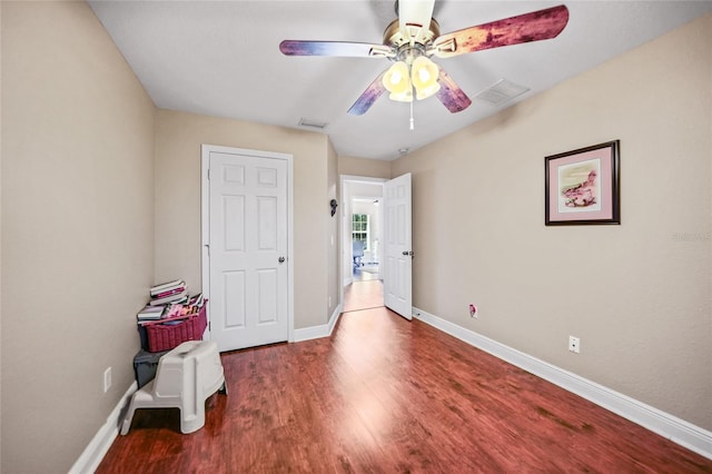 unfurnished bedroom with ceiling fan, wood finished floors, visible vents, and baseboards