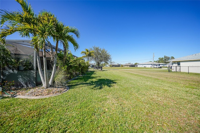 view of yard with a lanai and fence