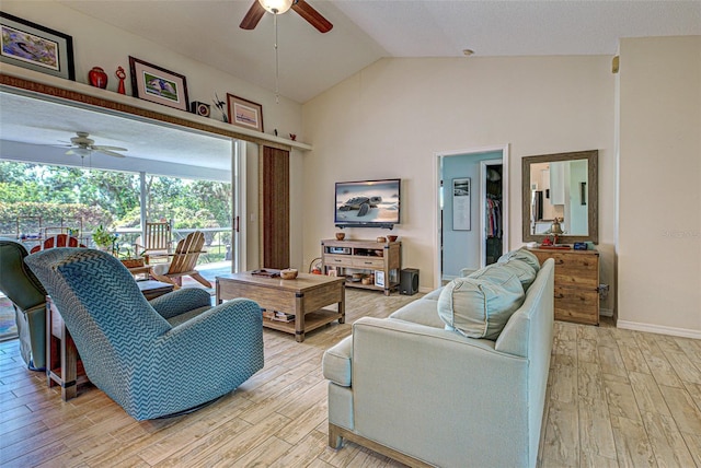 living room with light wood-type flooring, high vaulted ceiling, ceiling fan, and baseboards