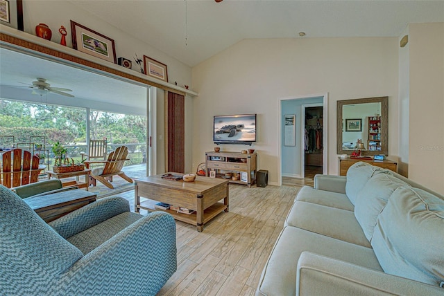 living area featuring light wood finished floors, baseboards, vaulted ceiling, and a ceiling fan