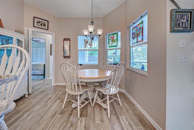 dining area featuring a notable chandelier, light wood-style flooring, and baseboards