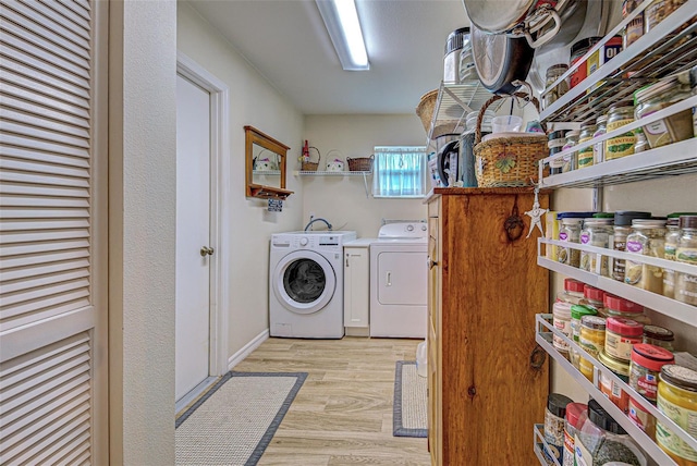 washroom with light wood-style flooring, laundry area, and washer and clothes dryer