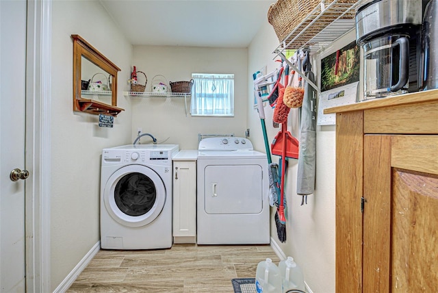 laundry area featuring laundry area, light wood finished floors, washing machine and clothes dryer, and baseboards