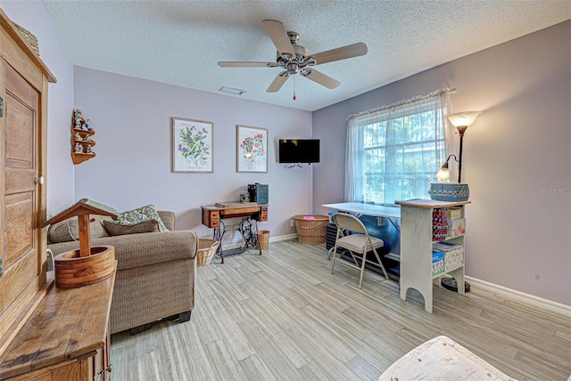 office area with visible vents, a ceiling fan, a textured ceiling, wood finished floors, and baseboards