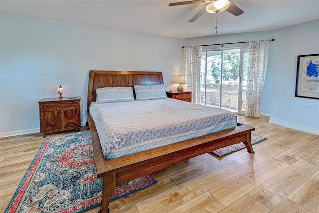 bedroom featuring a textured ceiling, wood finished floors, and baseboards