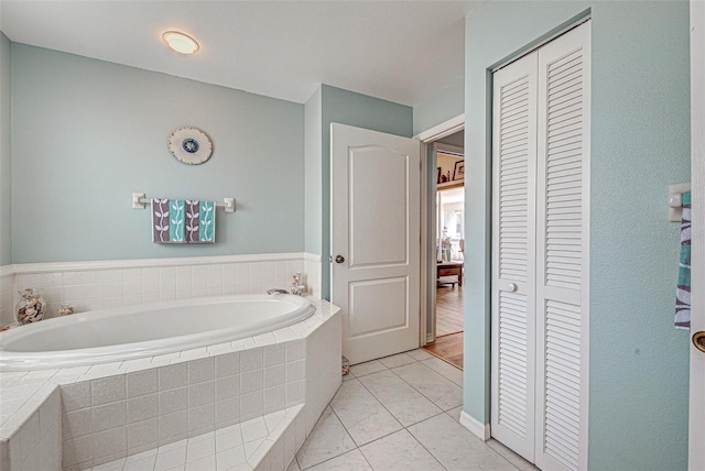 full bathroom featuring a bath and a closet