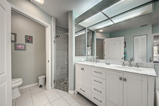 bathroom with a stall shower, a sink, toilet, and double vanity