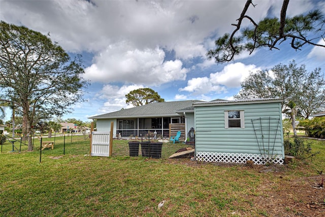 587 Viridian St, Englewood, FL 34223 - rear view of property with a lawn, fence, an outdoor structure, and a sunroom