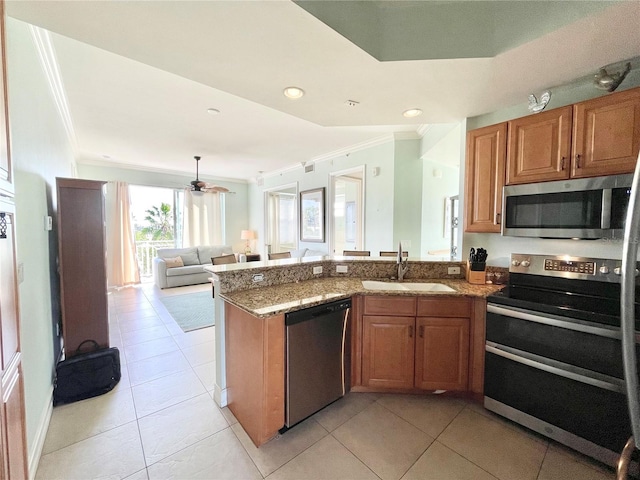 kitchen featuring ornamental molding, brown cabinets, a peninsula, stainless steel appliances, and a sink