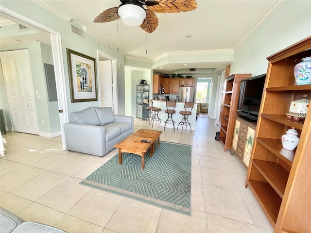 living area with ceiling fan, light tile patterned floors, visible vents, and ornamental molding