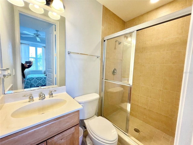 bathroom featuring connected bathroom, vanity, toilet, and a shower stall