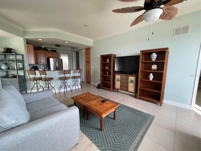 living area featuring light tile patterned floors, visible vents, and crown molding