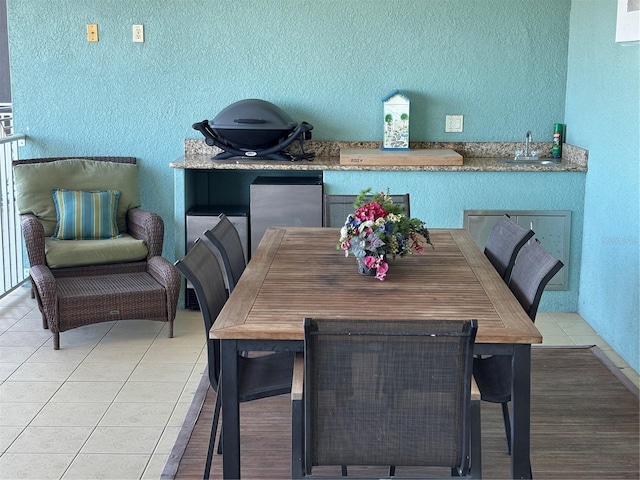 dining room featuring light tile patterned flooring and a textured wall