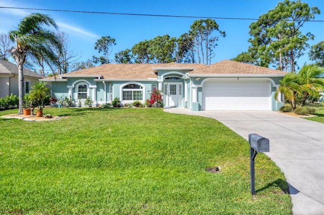 mediterranean / spanish-style home with stucco siding, an attached garage, concrete driveway, and a front lawn