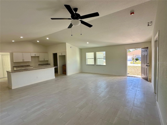 unfurnished living room with lofted ceiling, baseboards, a ceiling fan, and recessed lighting