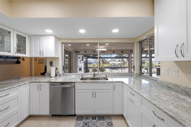 kitchen with plenty of natural light, dishwasher, white cabinetry, and a sink