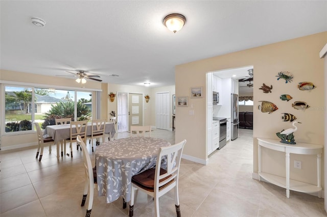 dining room featuring light tile patterned flooring, baseboards, and ceiling fan