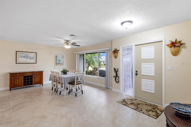 dining area featuring a ceiling fan, baseboards, visible vents, and a textured ceiling