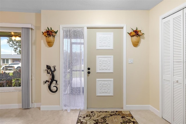 foyer with light tile patterned floors and baseboards