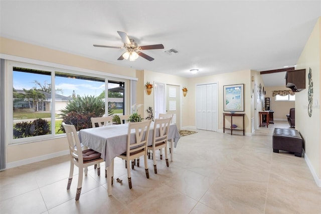 dining space with a ceiling fan, light tile patterned floors, baseboards, and visible vents