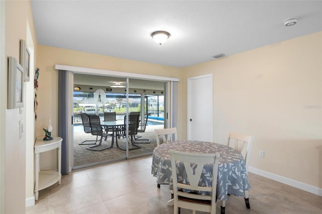 dining space featuring light tile patterned flooring, visible vents, and baseboards