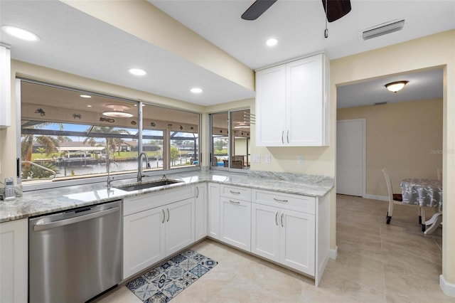 kitchen with visible vents, light stone counters, stainless steel dishwasher, white cabinets, and a sink