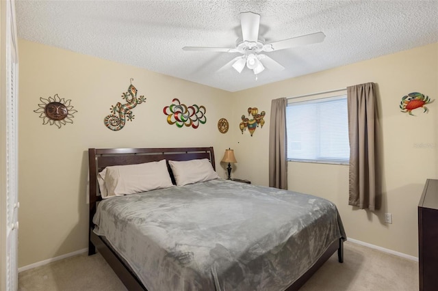 bedroom with baseboards, light carpet, and a textured ceiling