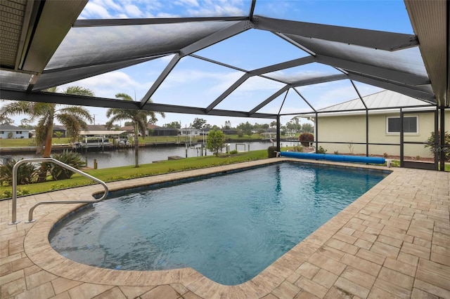 pool with glass enclosure, a patio, and a water view