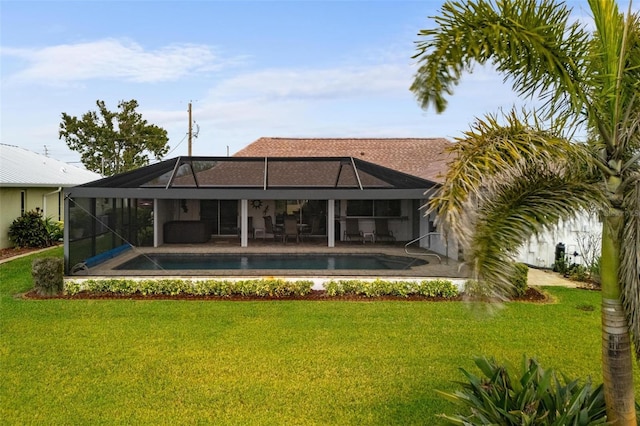 back of house featuring an outdoor pool, a yard, a patio, and a lanai