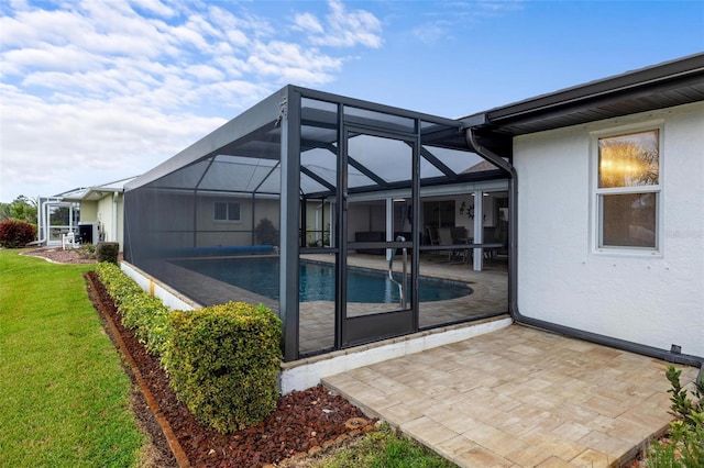 back of house with stucco siding, a yard, an outdoor pool, a lanai, and a patio area