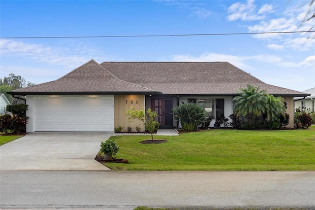 ranch-style house featuring an attached garage, concrete driveway, a front yard, and roof with shingles