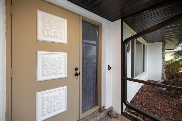 entrance to property featuring stucco siding